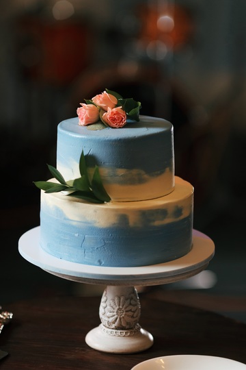 blue and white cake topped with pink roses